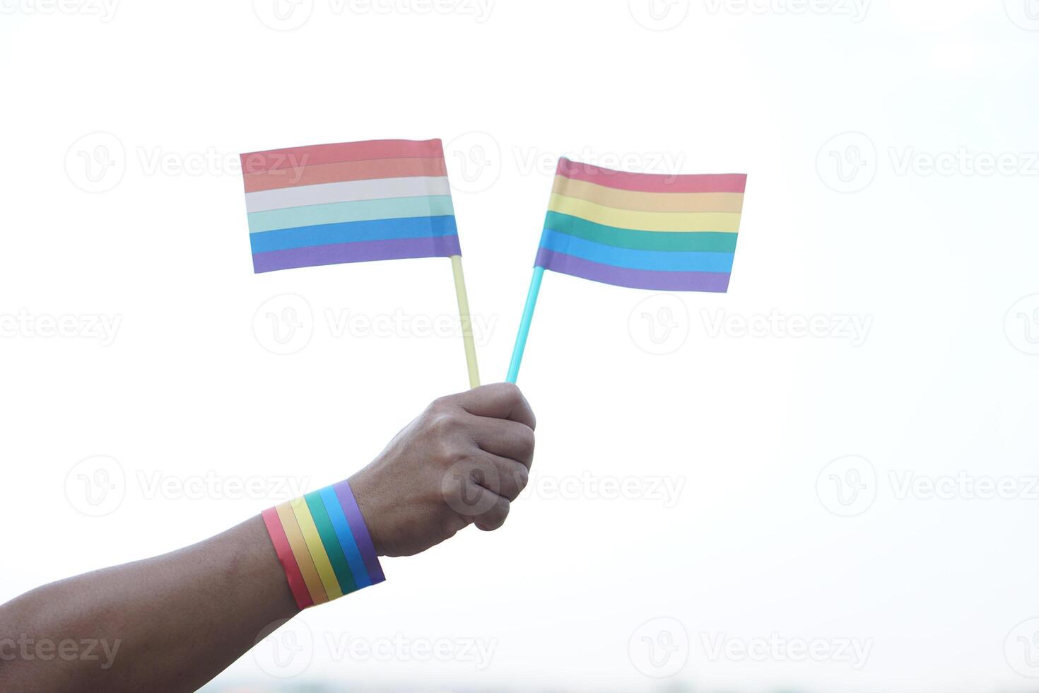 Close up hand holds rainbow colors flags. Concept, Lgbtq celebration in pride month, June. Symbol of LGBT community around the world.Support human right of gender diversity. photo