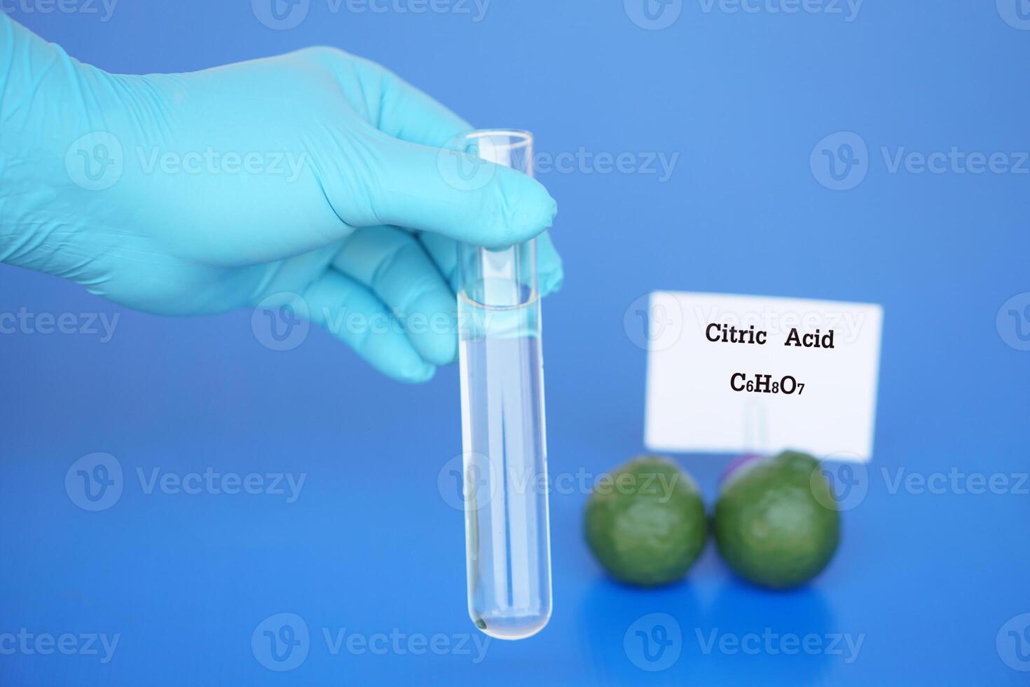 Hand in blue glove hold glass test tube to do science experiment about Citric Acid with molecular formula C6H8O7 from fruits. Concept, Education, Science laboratory lesson. photo