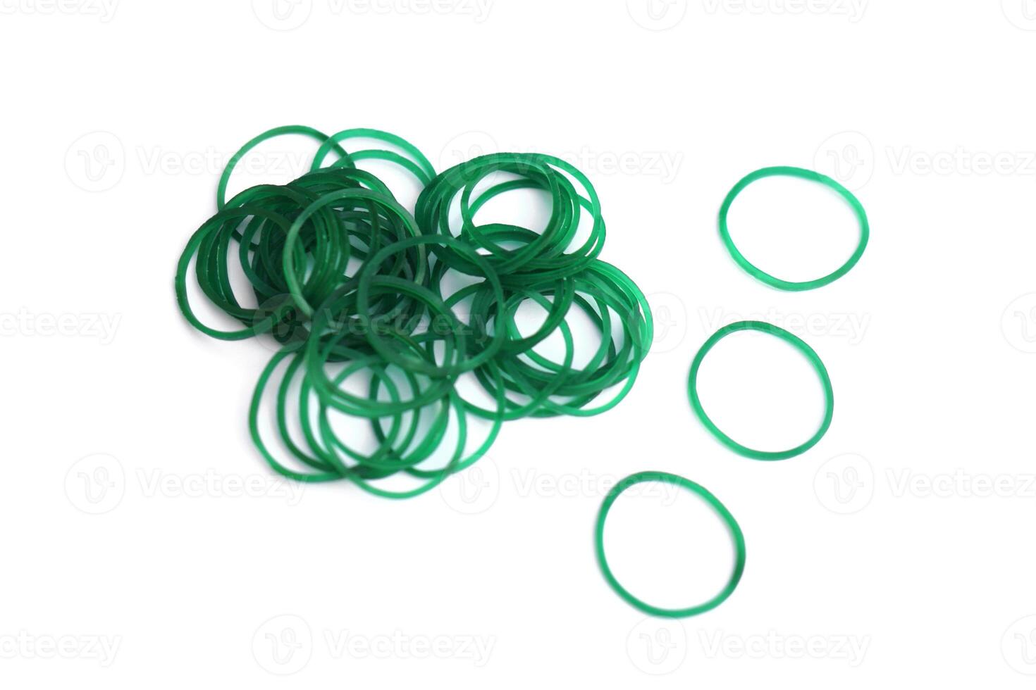 Elastic green rubber bands in ring or oval shape on white background. Concept, equipment that use for tie multiple objects together, use in office or household item that can be used in various purpose photo