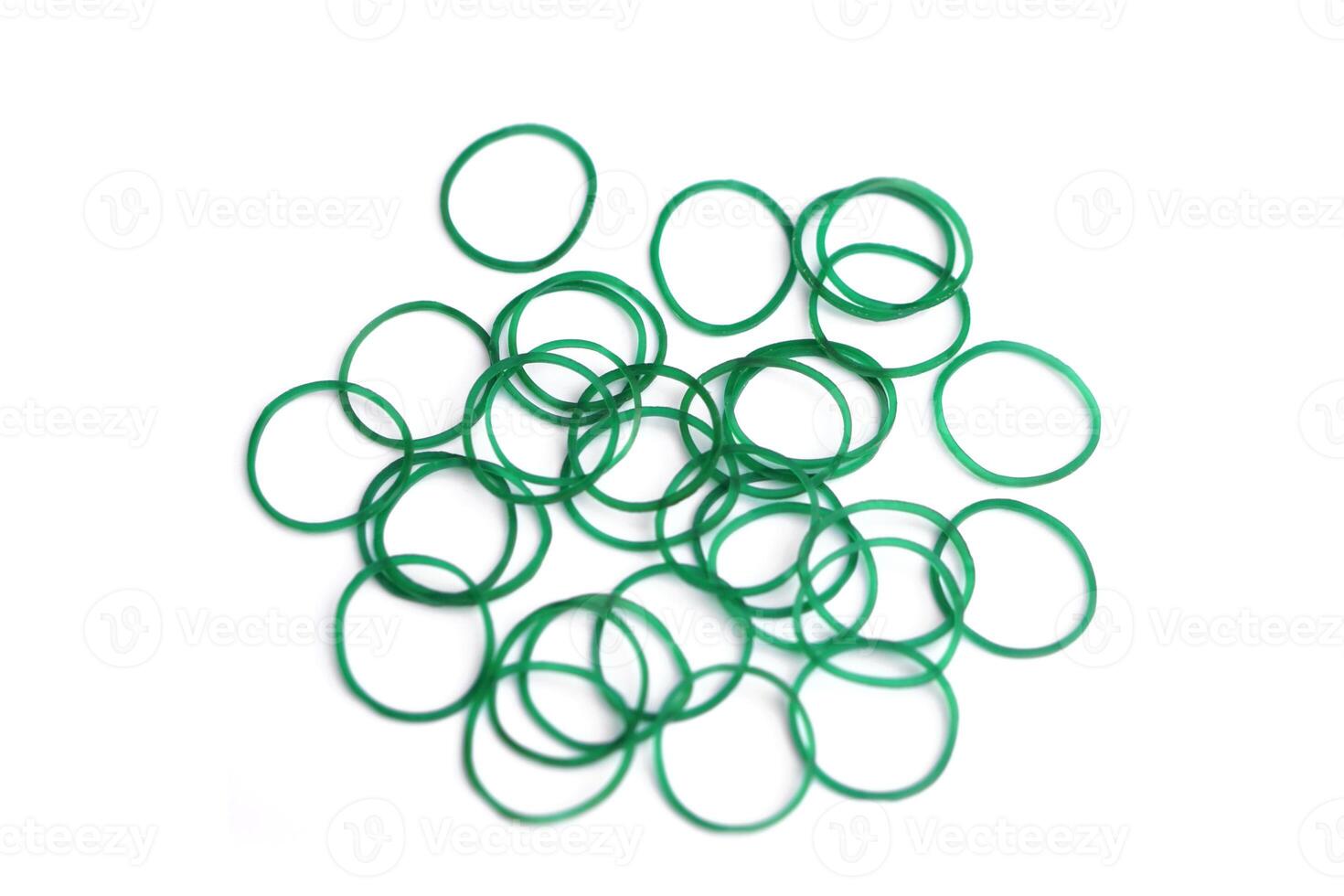 Elastic green rubber bands in ring or oval shape on white background. Concept, equipment that use for tie multiple objects together, use in office or household item that can be used in various purpose photo
