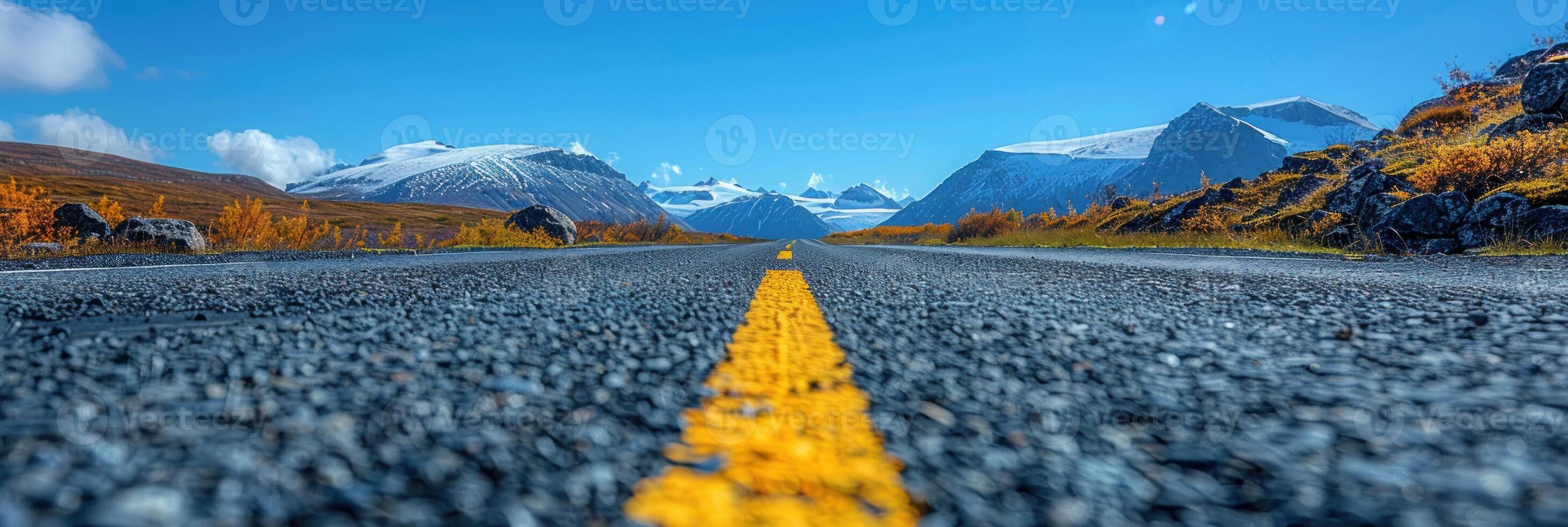 Deserted road stretches toward majestic mountains in the distance photo