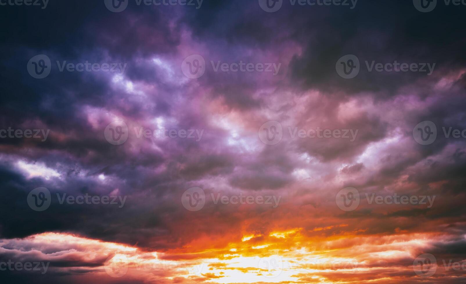 Dramatic cloudy sky illuminated by the rays at sunset or sunrise. Vintage film aesthetic. photo
