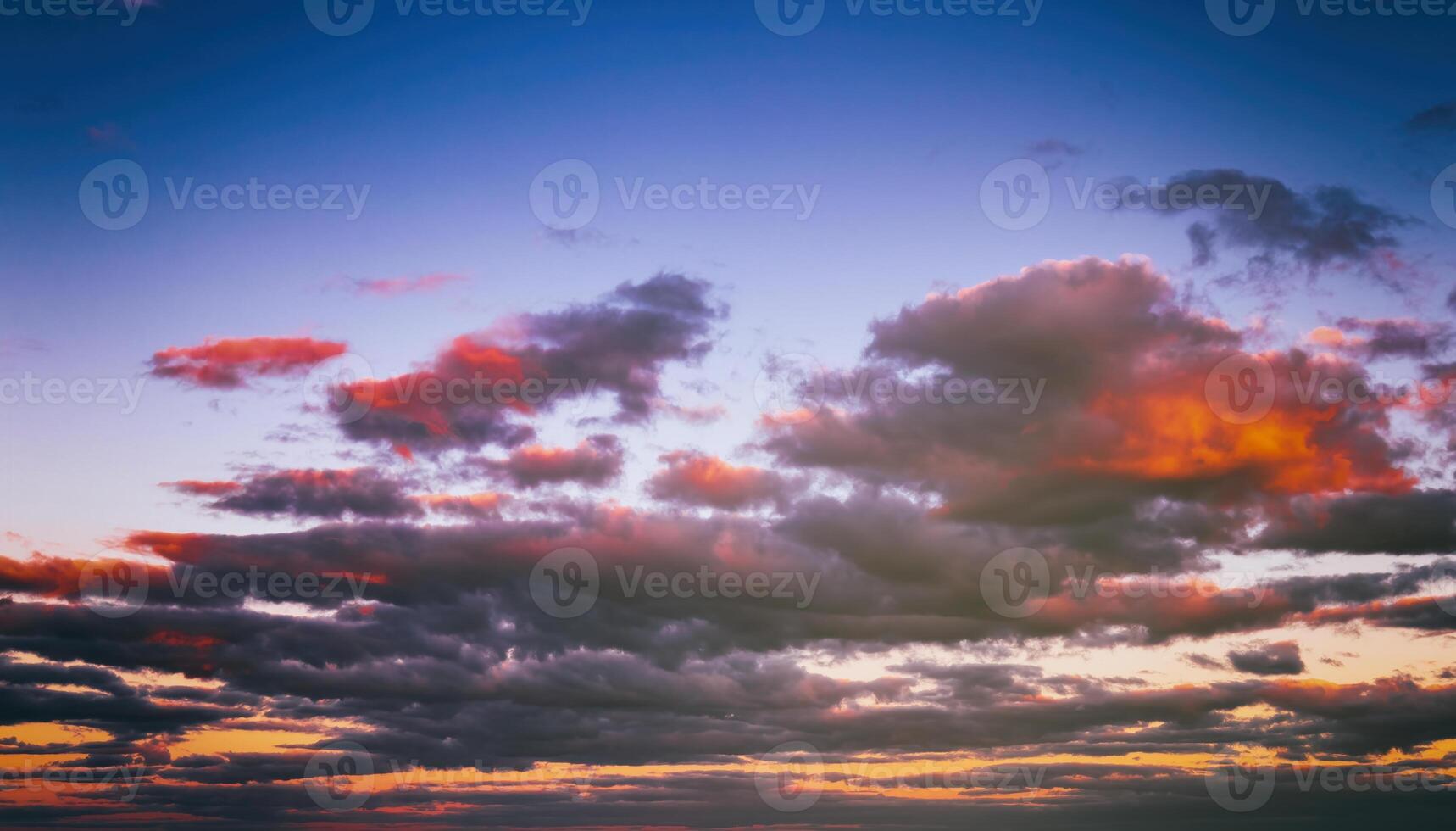 Dramatic cloudy sky illuminated by the rays at sunset or sunrise. Vintage film aesthetic. photo