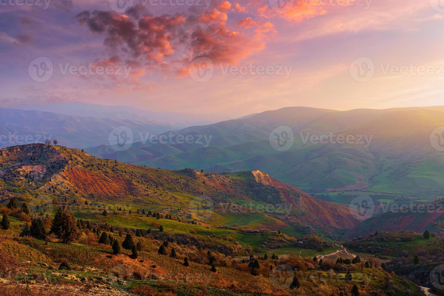 Foggy sunset or dawn in the mountains covered with grass and cloudy dramatic sky. photo