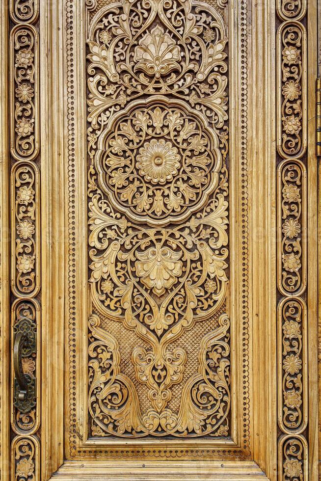 Fragment of an ancient carved wooden door. Ornate. photo