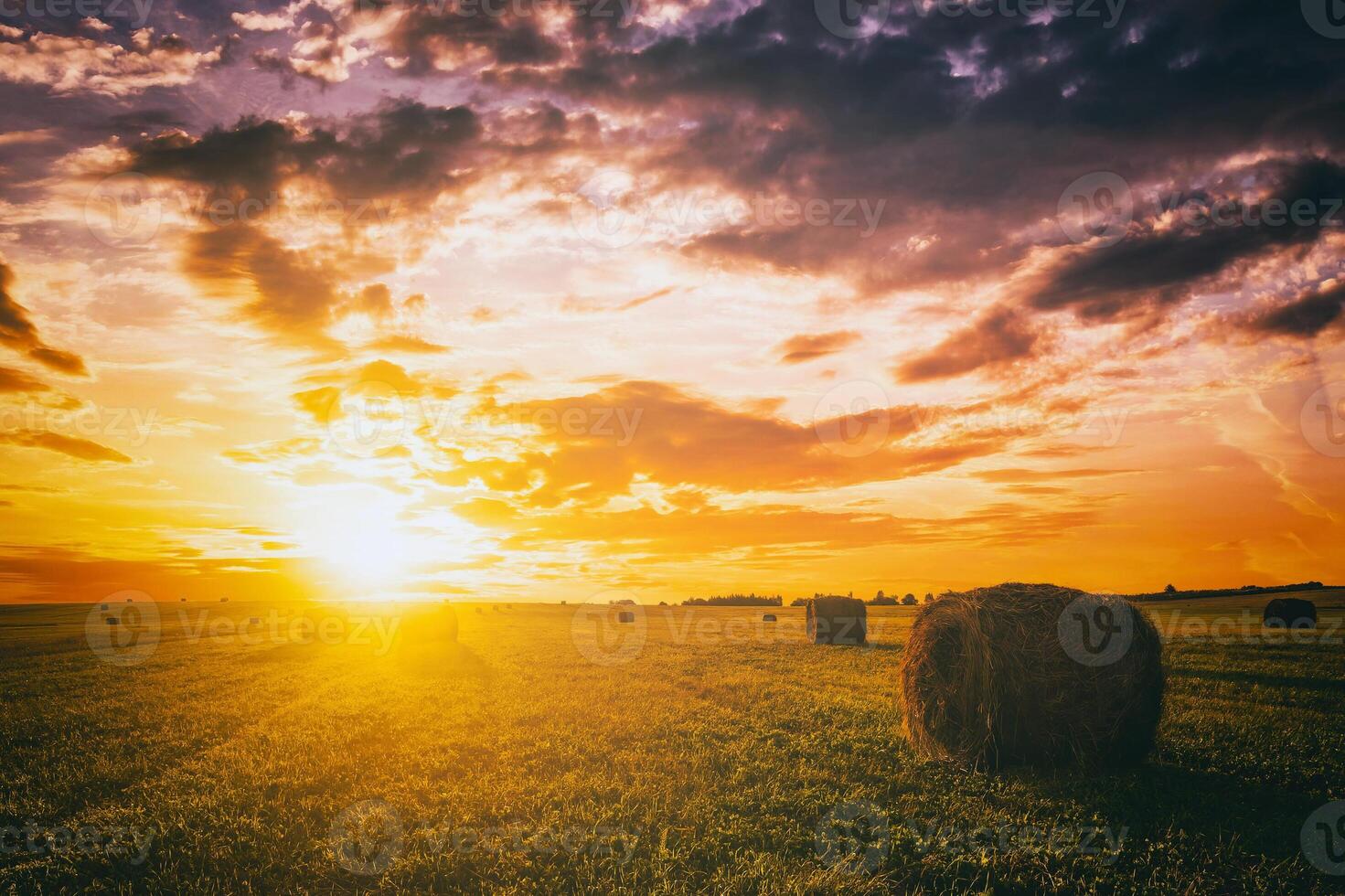 puesta de sol en un campo con pajar en un verano o temprano otoño noche con un nublado cielo en el antecedentes. obtención de animal alimentar en agricultura. Clásico película estético. foto