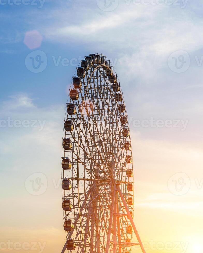 High ferris wheel at sunset or sunrise with cloudy sky background. photo