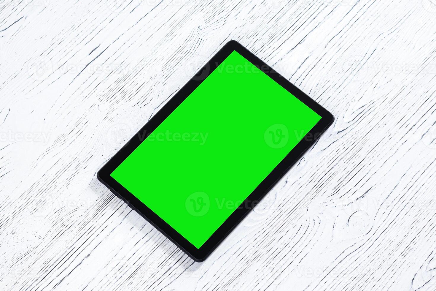 negro tableta con verde pantalla en un de madera mesa burlarse de arriba. Copiar espacio croma llave mostrar. foto
