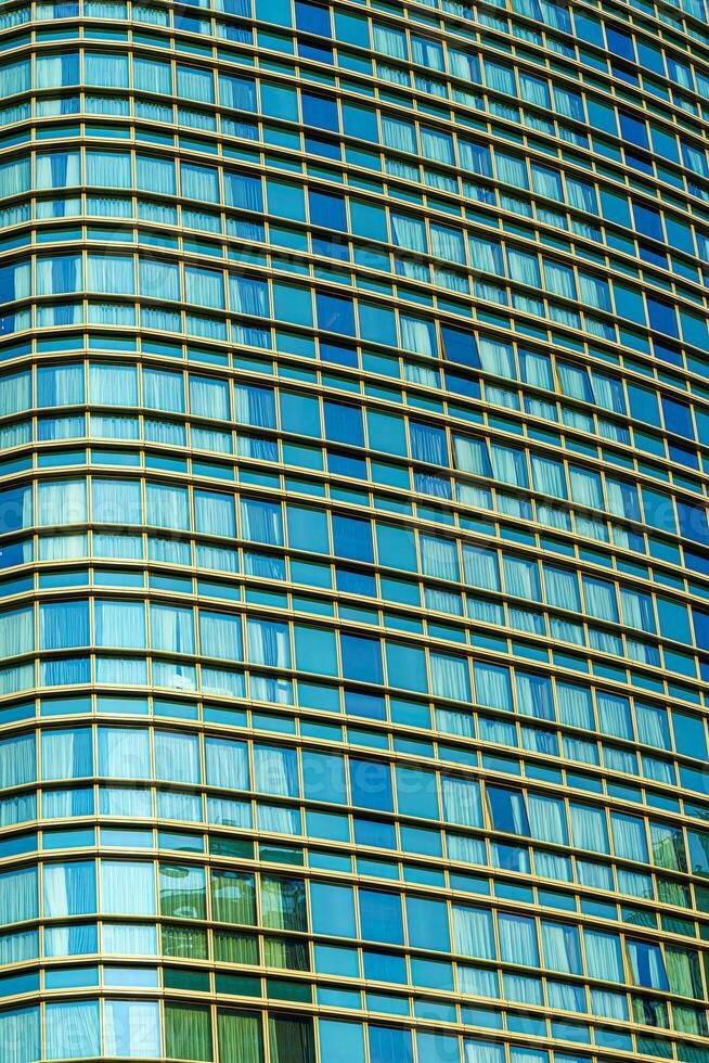 Fragment of a modern office building. Abstract geometric background. Part of a skyscraper with glass windows. photo