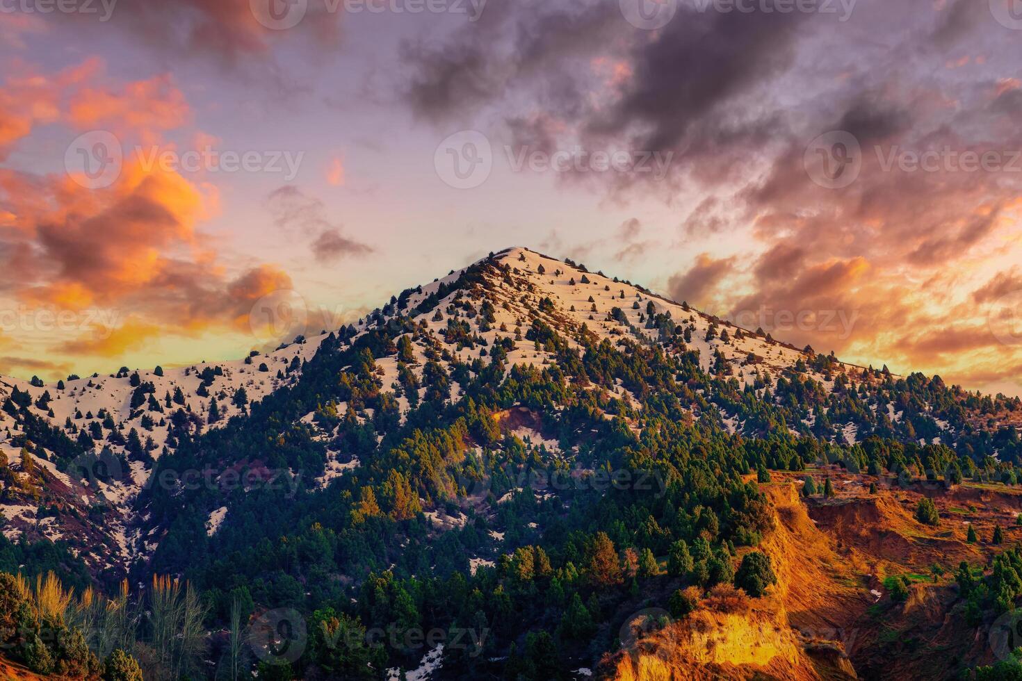 Mountain top covered with young snow and illuminated by the sun on a sunny day. Mountain landscape. photo