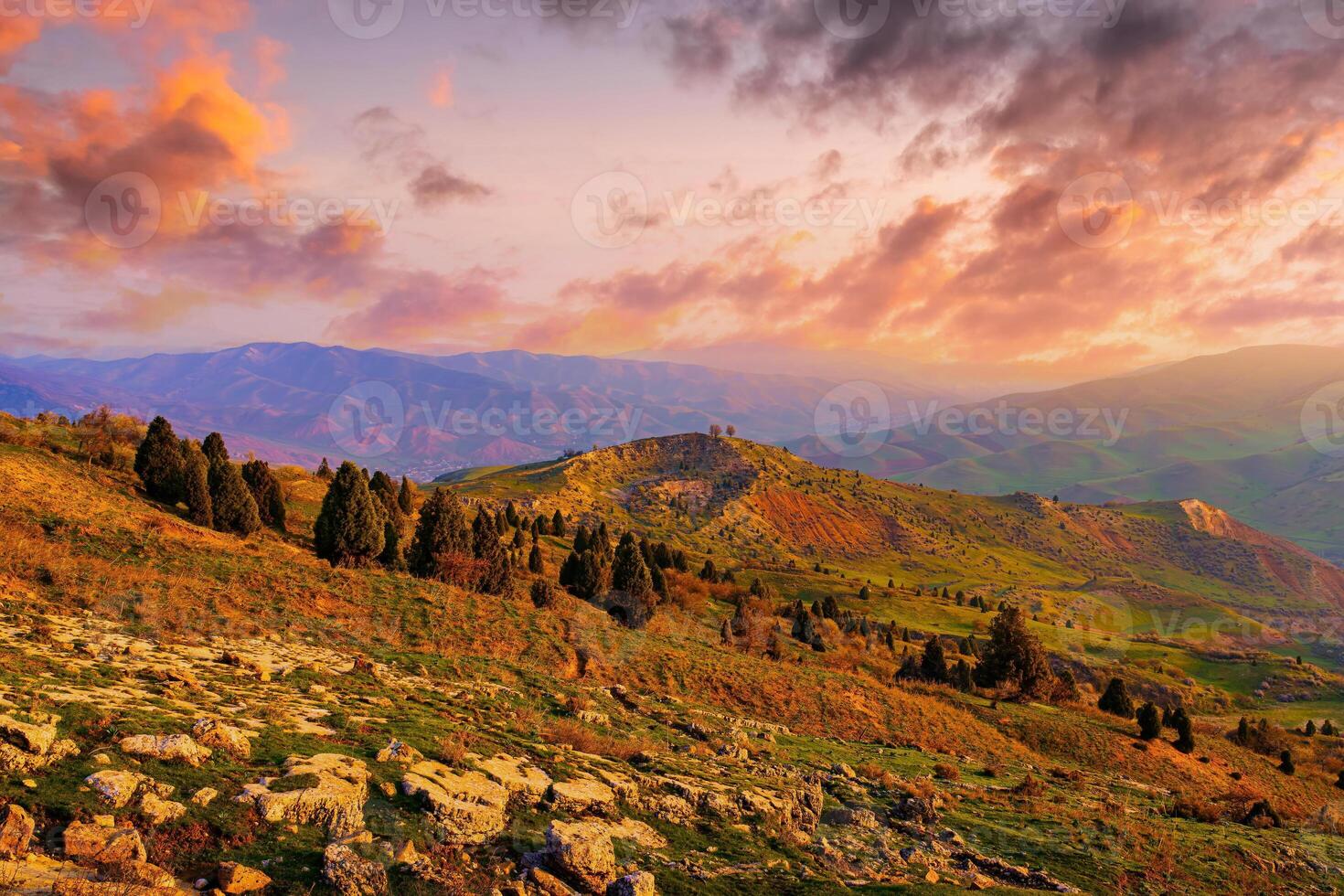 Foggy sunset or dawn in the mountains covered with grass and cloudy dramatic sky. photo