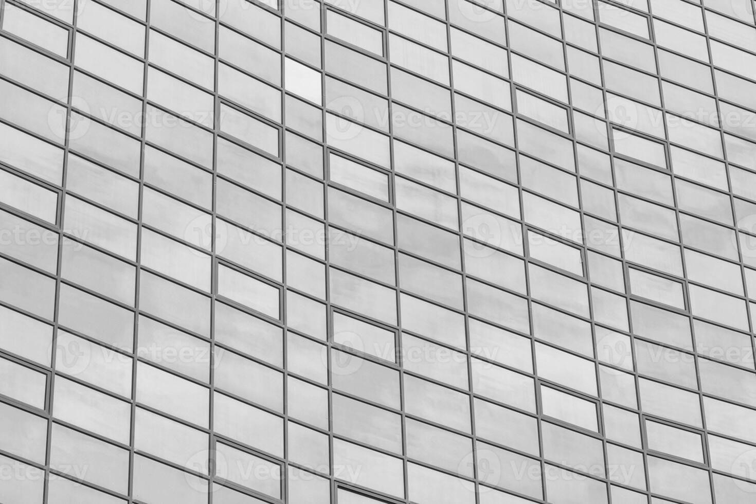 Black and white fragment of a modern office building. Abstract geometric background. Part of the facade of a skyscraper with glass windows. photo