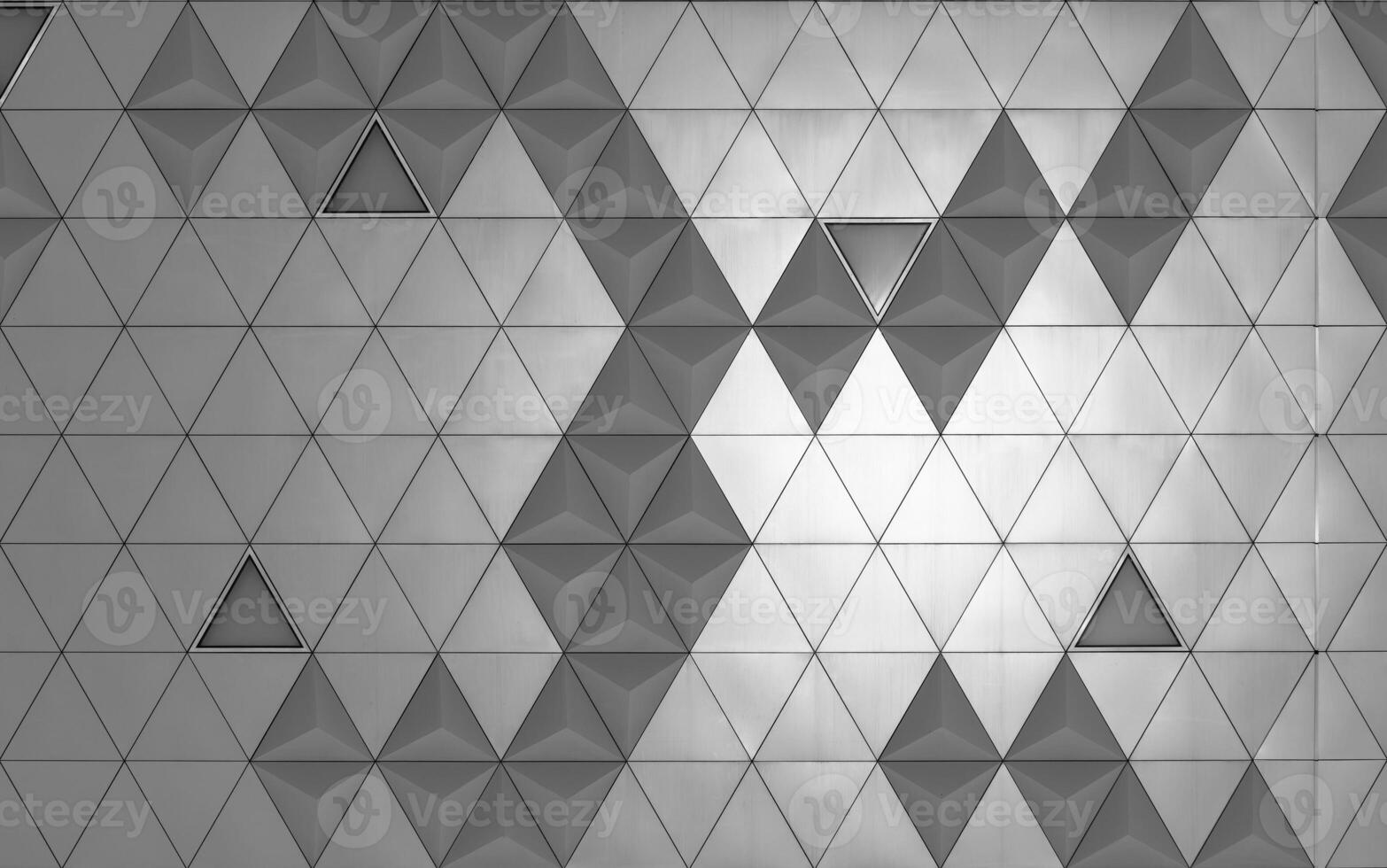 Steel diamond-shaped polished metal cladding panels of a modern building. Abstract monochrome background. photo