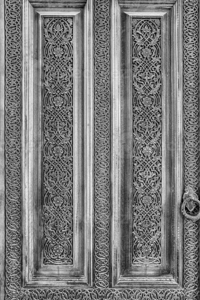 Carved wooden doors with patterns and mosaics. Black and white. photo