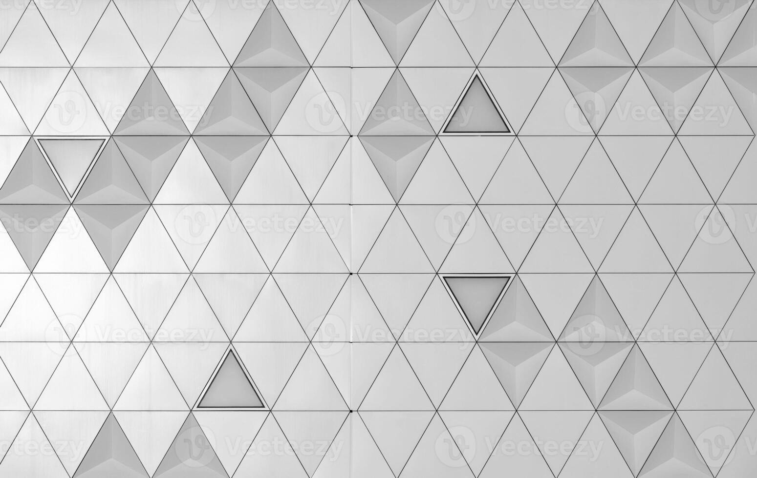 Steel diamond-shaped polished metal cladding panels of a modern building. Abstract monochrome background. photo