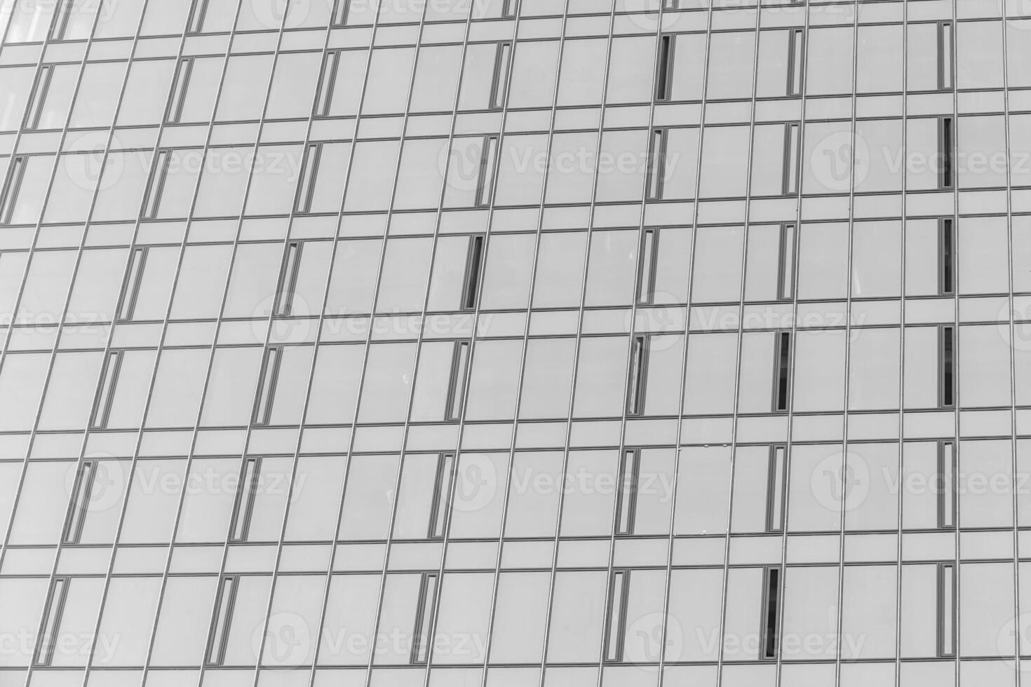 Fragment of a modern office building. Abstract geometric background. Part of the facade of a skyscraper with glass windows. Black and white. photo