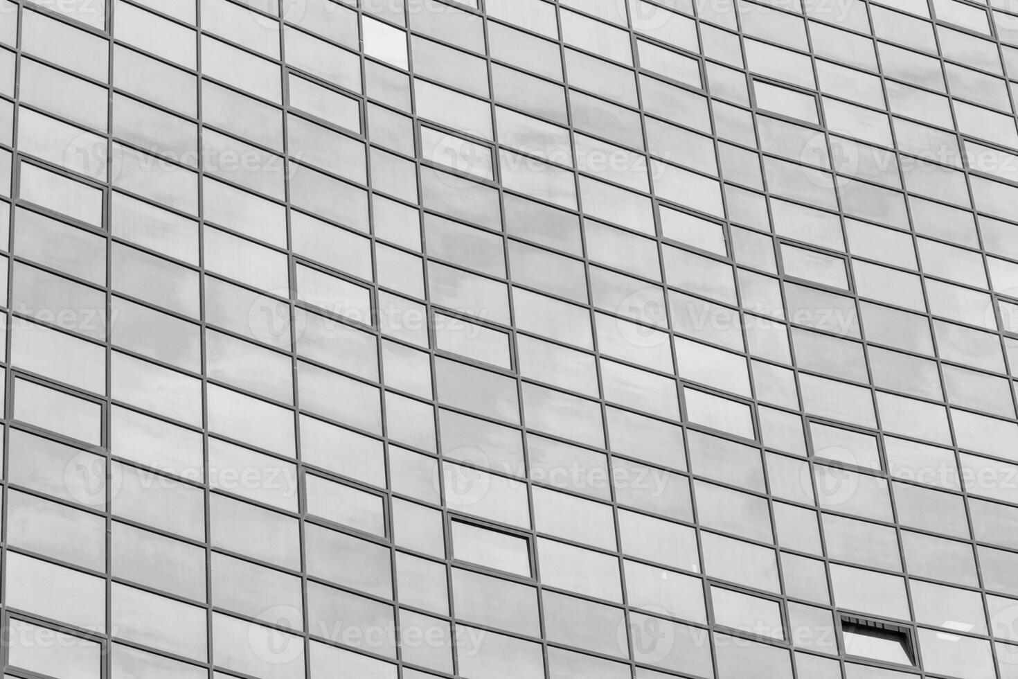 Black and white fragment of a modern office building. Abstract geometric background. Part of the facade of a skyscraper with glass windows. photo