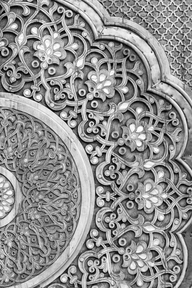 Carved wooden doors with patterns and mosaics. Black and white. photo