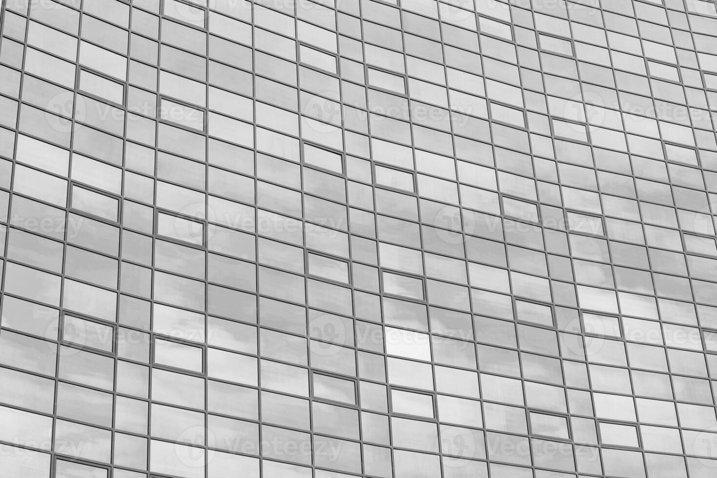 Black and white fragment of a modern office building. Abstract geometric background. Part of the facade of a skyscraper with glass windows. photo