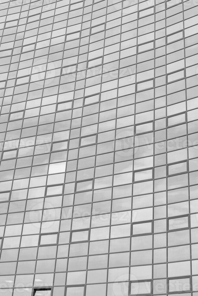 Black and white fragment of a modern office building. Abstract geometric background. Part of the facade of a skyscraper with glass windows. photo