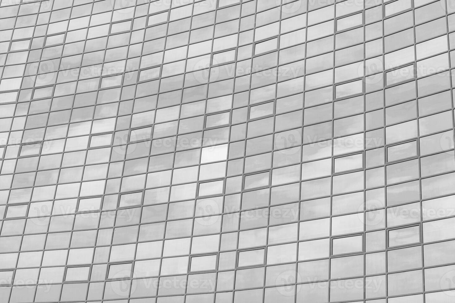 Black and white fragment of a modern office building. Abstract geometric background. Part of the facade of a skyscraper with glass windows. photo