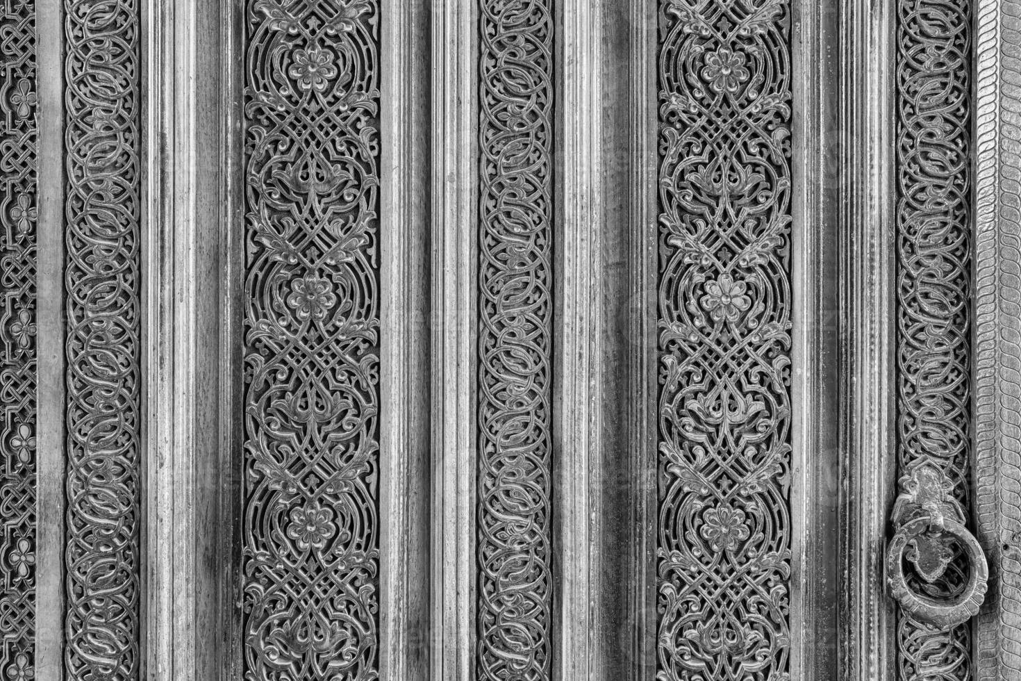 Carved wooden doors with patterns and mosaics. Black and white. photo