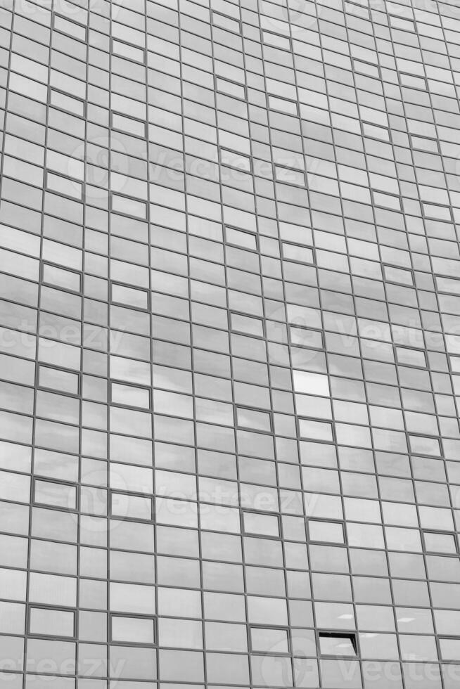 Black and white fragment of a modern office building. Abstract geometric background. Part of the facade of a skyscraper with glass windows. photo