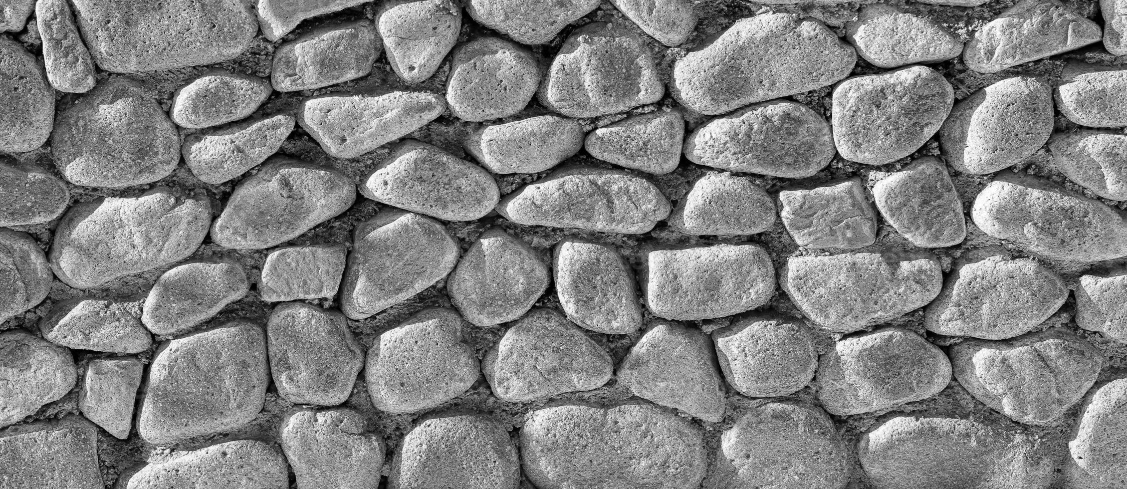 Black and white texture of an old antique stone wall. Abstract background. photo