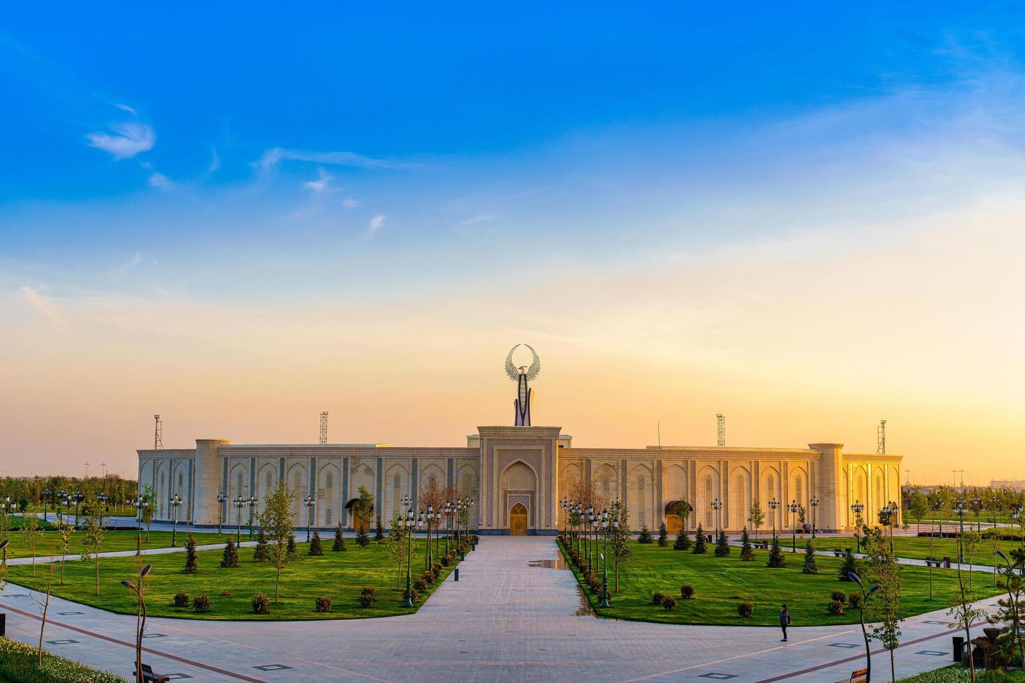 UZBEKISTAN, TASHKENT - APRIL 25, 2023 The territory of the park New Uzbekistan with Monument of Independence in the form of a stele with a Humo bird at twilight. photo