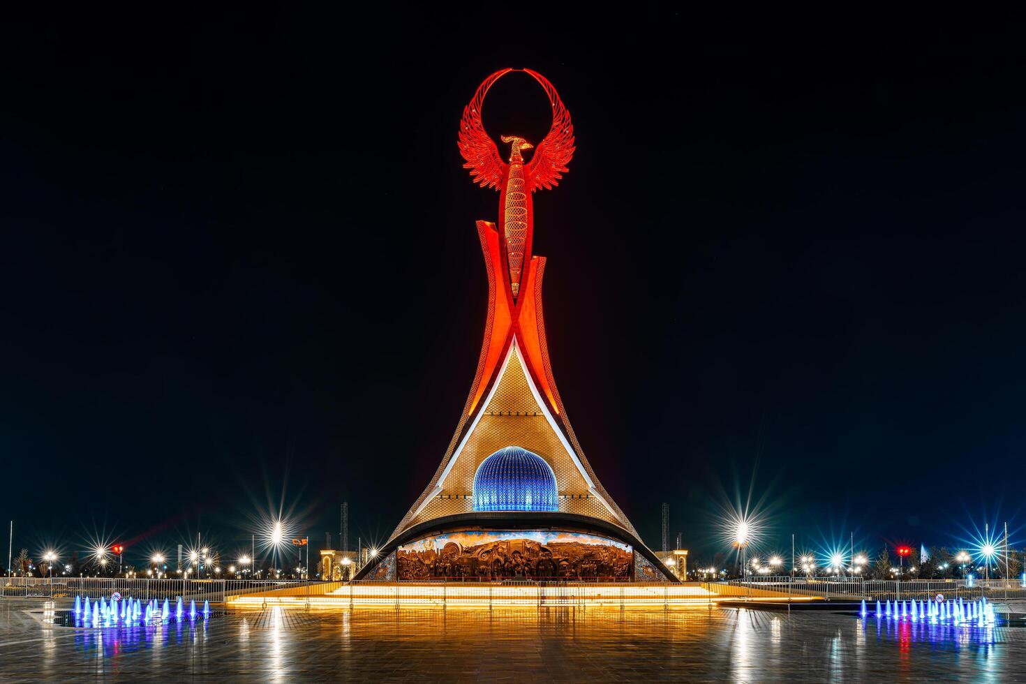 UZBEKISTAN, TASHKENT - APRIL 25, 2023 Illuminated monument of independence in the form of a stele with a Humo bird in the New Uzbekistan park at nighttime. photo