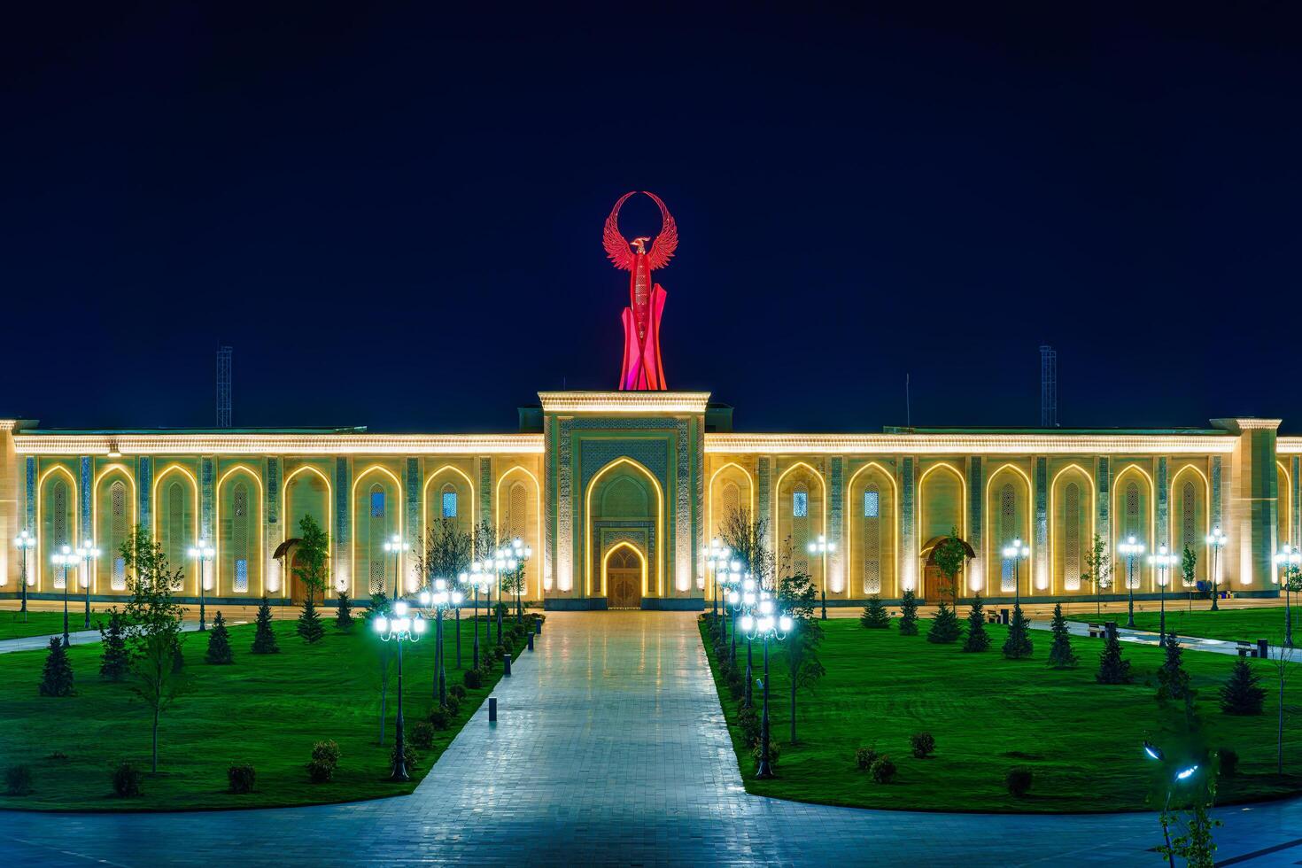 UZBEKISTAN, TASHKENT - APRIL 25, 2023 The territory of the park New Uzbekistan with Monument of Independence in the form of a stele with a Humo bird at night. photo