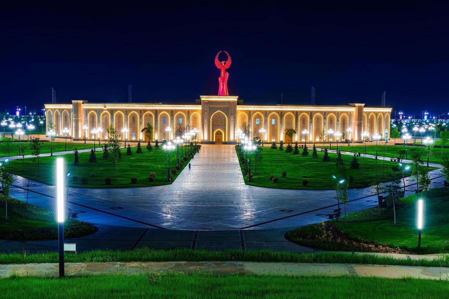 UZBEKISTAN, TASHKENT - APRIL 25, 2023 The territory of the park New Uzbekistan with Monument of Independence in the form of a stele with a Humo bird at night. photo