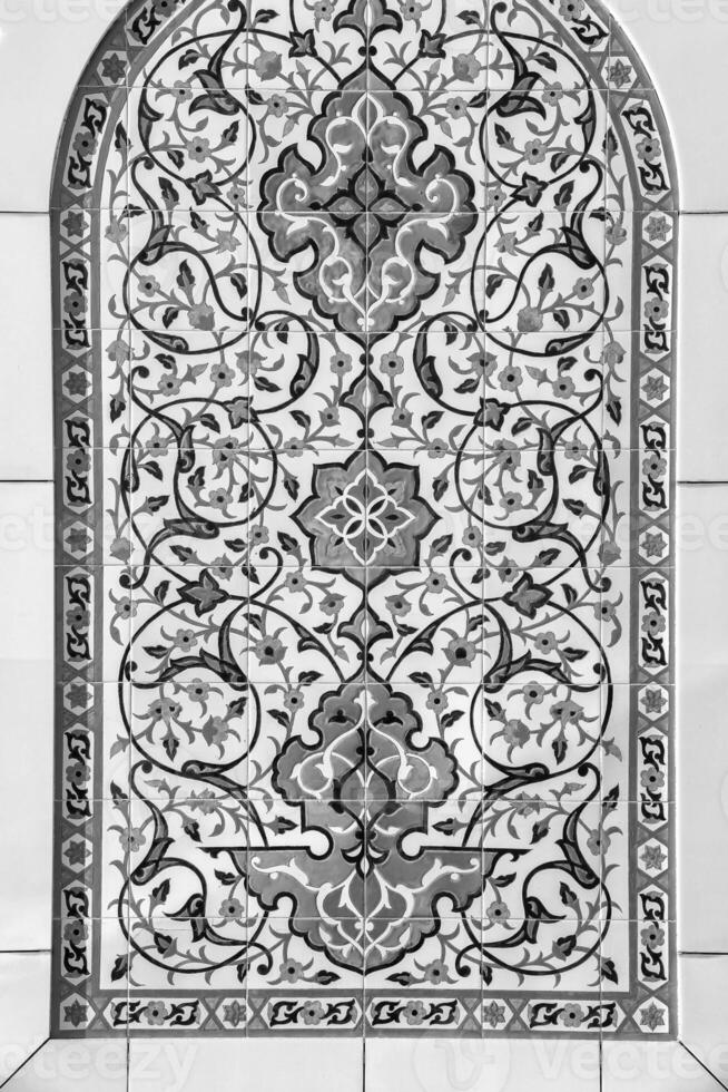 Black and white geometric traditional Islamic ornament on a tile. Fragment of a ceramic mosaic.Abstract background. photo