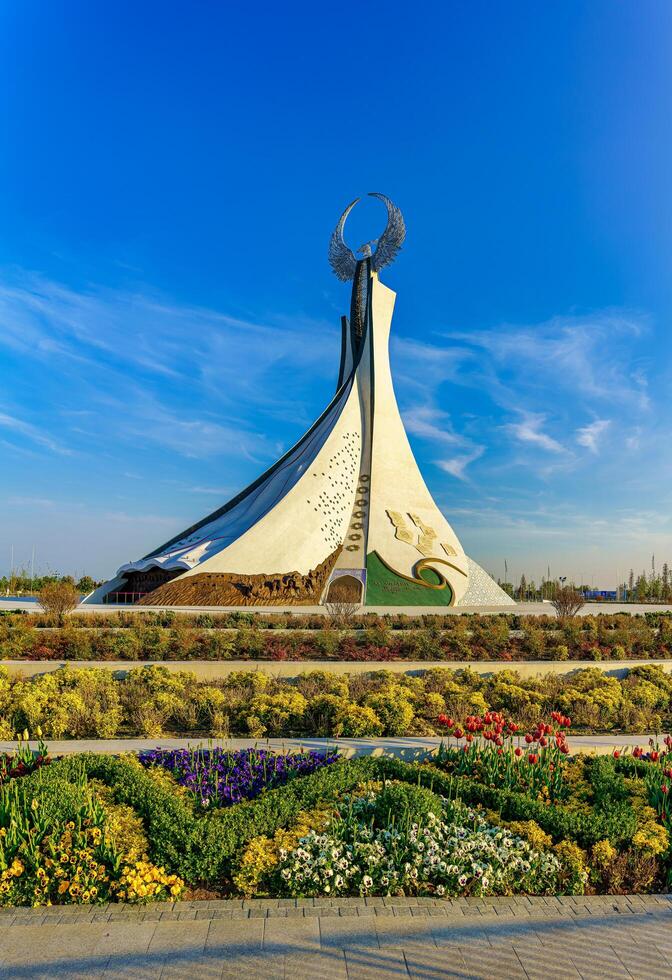 UZBEKISTAN, TASHKENT - APRIL 25, 2023 Monument of Independence in the form of a stele with a Humo bird against a blue sky in the New Uzbekistan park. photo