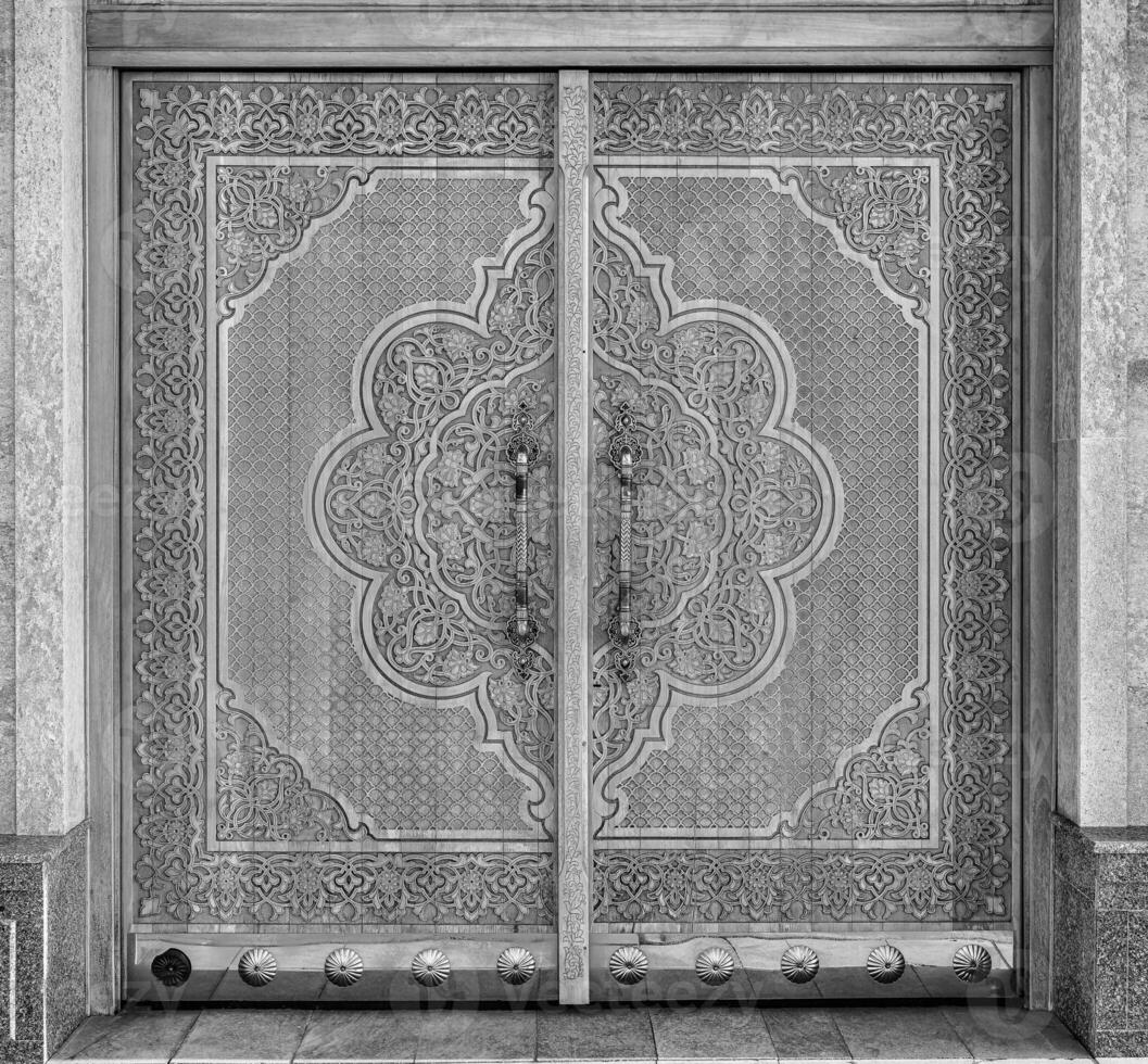 Carved wooden doors with patterns and mosaics. Black and white. photo