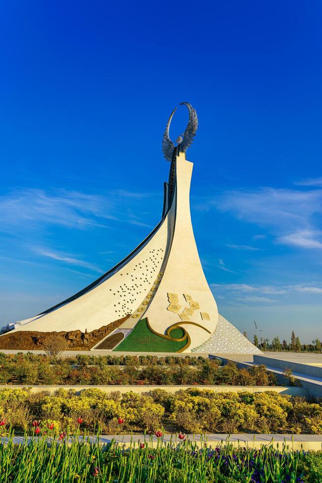 UZBEKISTAN, TASHKENT - APRIL 25, 2023 Monument of Independence in the form of a stele with a Humo bird against a blue sky in the New Uzbekistan park. photo