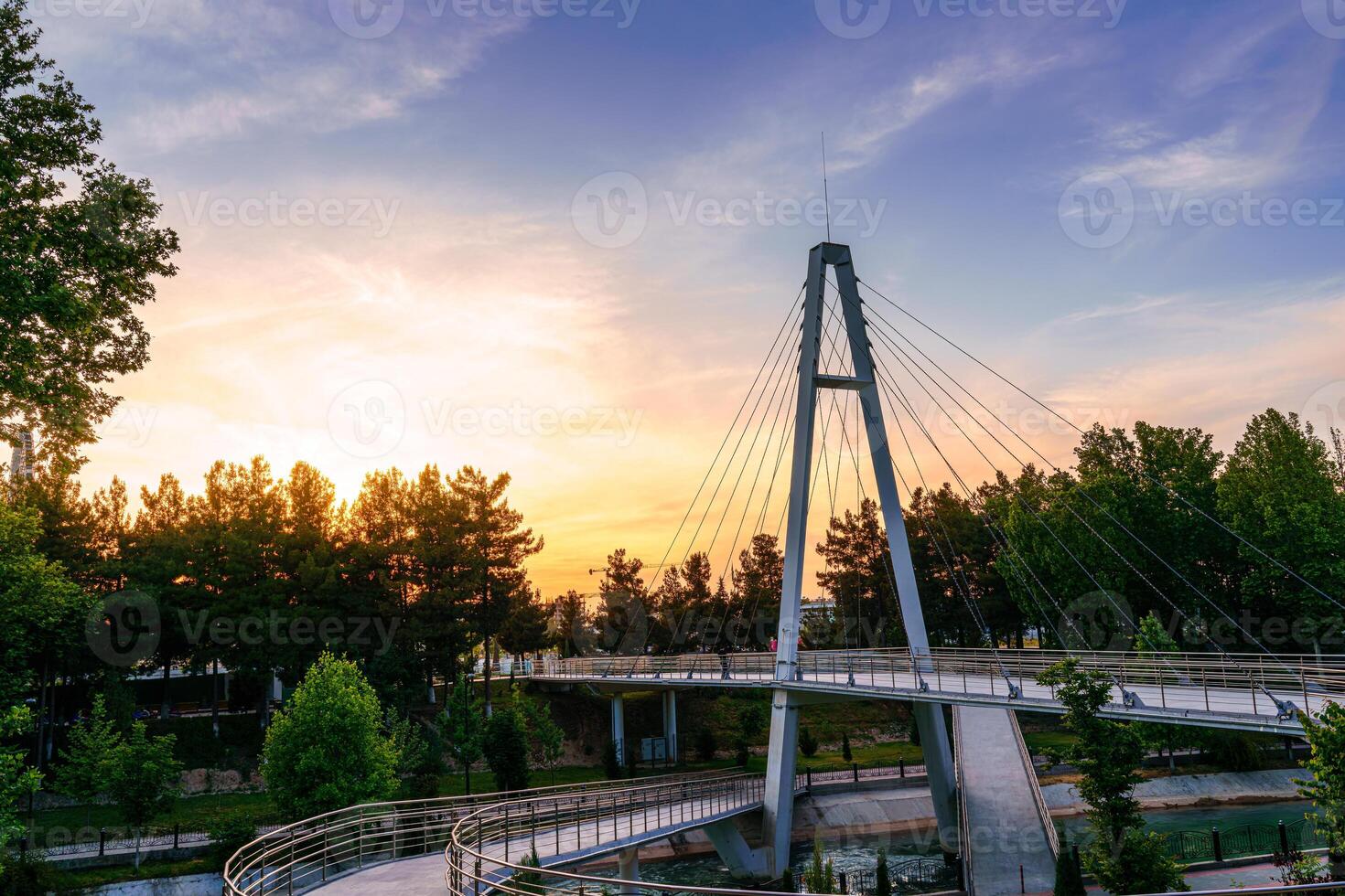 Modern footbridge across the Anhor canal in Navruz park at sunset in summertime, Uzbekistan, Tashkent. photo