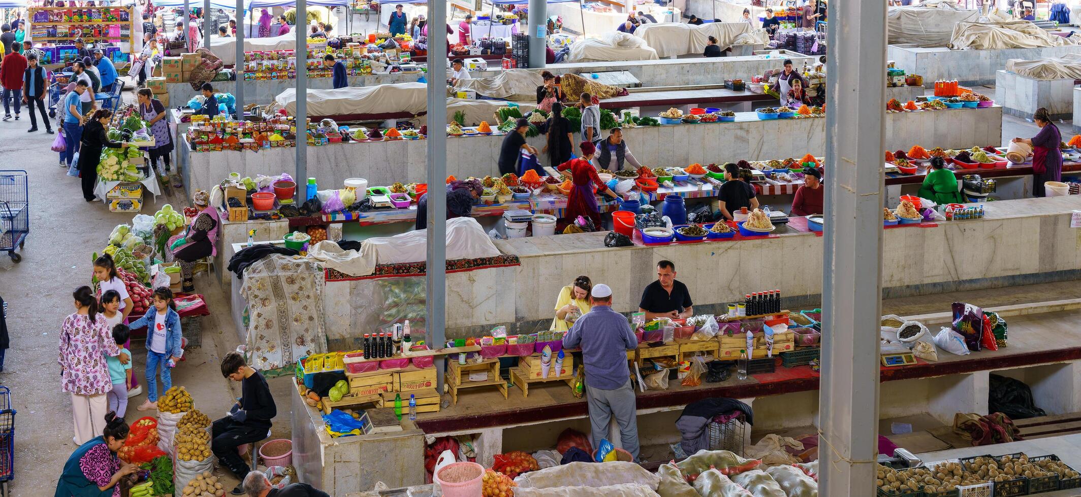 Samarkand, Uzbekistan - April 27, 2023 Top view of rows of fruit and vegetable stalls and vendors in an oriental bazaar in central Asia. photo