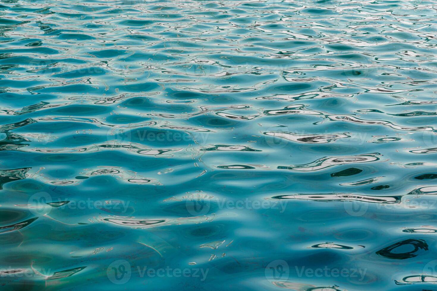 The texture of the waves in turquoise color, illuminated by the sun at sunset or dawn. Nature background. photo