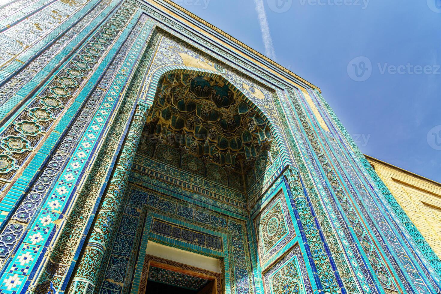 The ancient mausoleum of Shakh-I-Zinda, The Tomb of living King, during the reign of Amir Temur in Samarkand. Necropolis arch decorated with geometric Islamic oriental ornament. photo