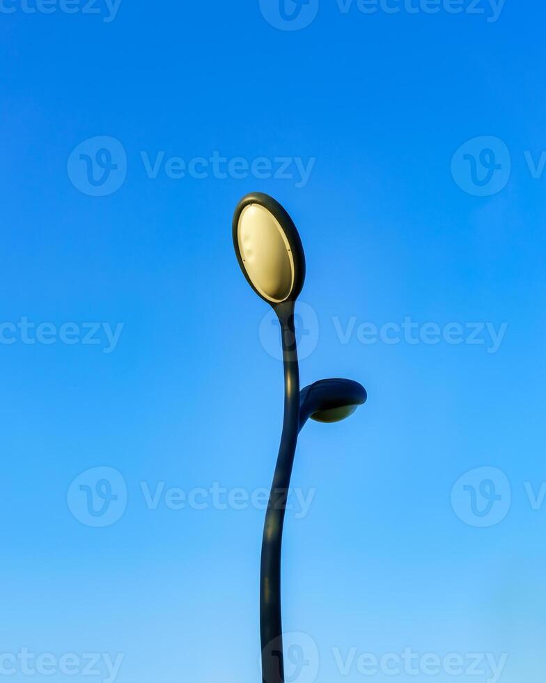 Pillar with modern LED lantern against the blue sky. photo