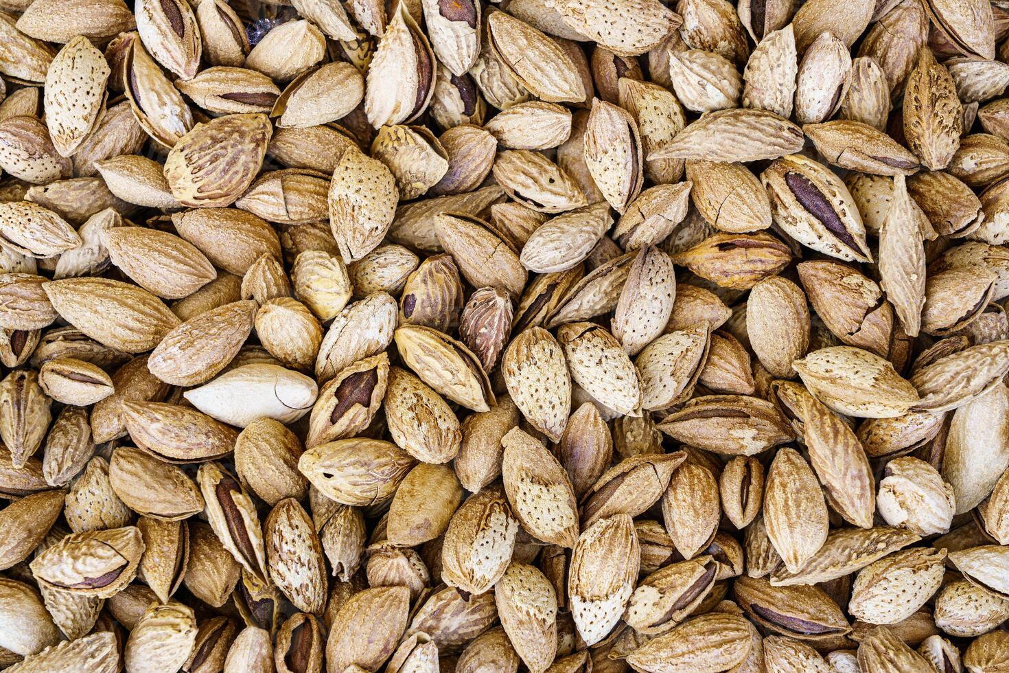 The texture of a heap of almonds in a shell. Background of healthy plant vegan food. Nuts. photo