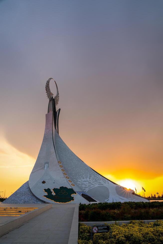 UZBEKISTAN, TASHKENT - APRIL 25, 2023 Monument of Independence in the form of a stele with a Humo bird on a sunset in the New Uzbekistan. photo