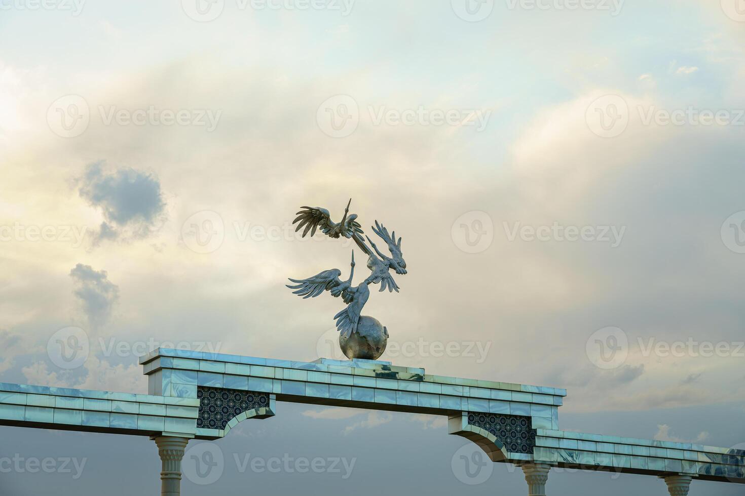 monumento y filas de fuentes iluminado por luz de sol a puesta de sol o amanecer en el independencia cuadrado a Hora de verano, Taskent. foto