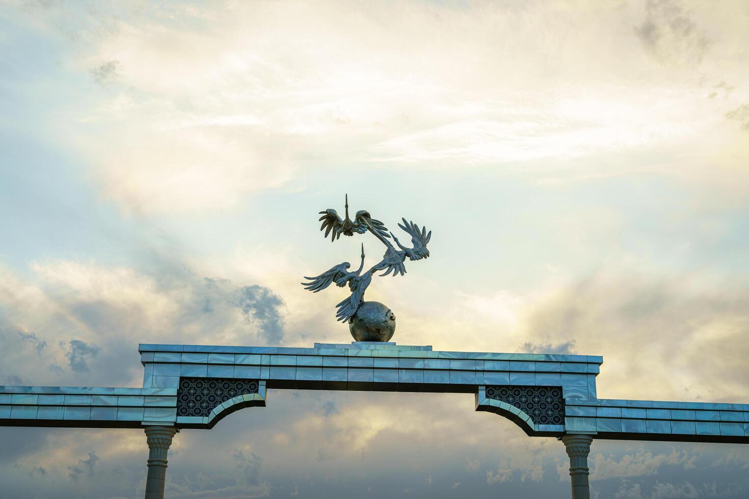 TASHKENT, UZBEKISTAN - MAY 25, 2023 Independence Memorial at Independence Square in Tashkent at sunset with cloudy sky. photo