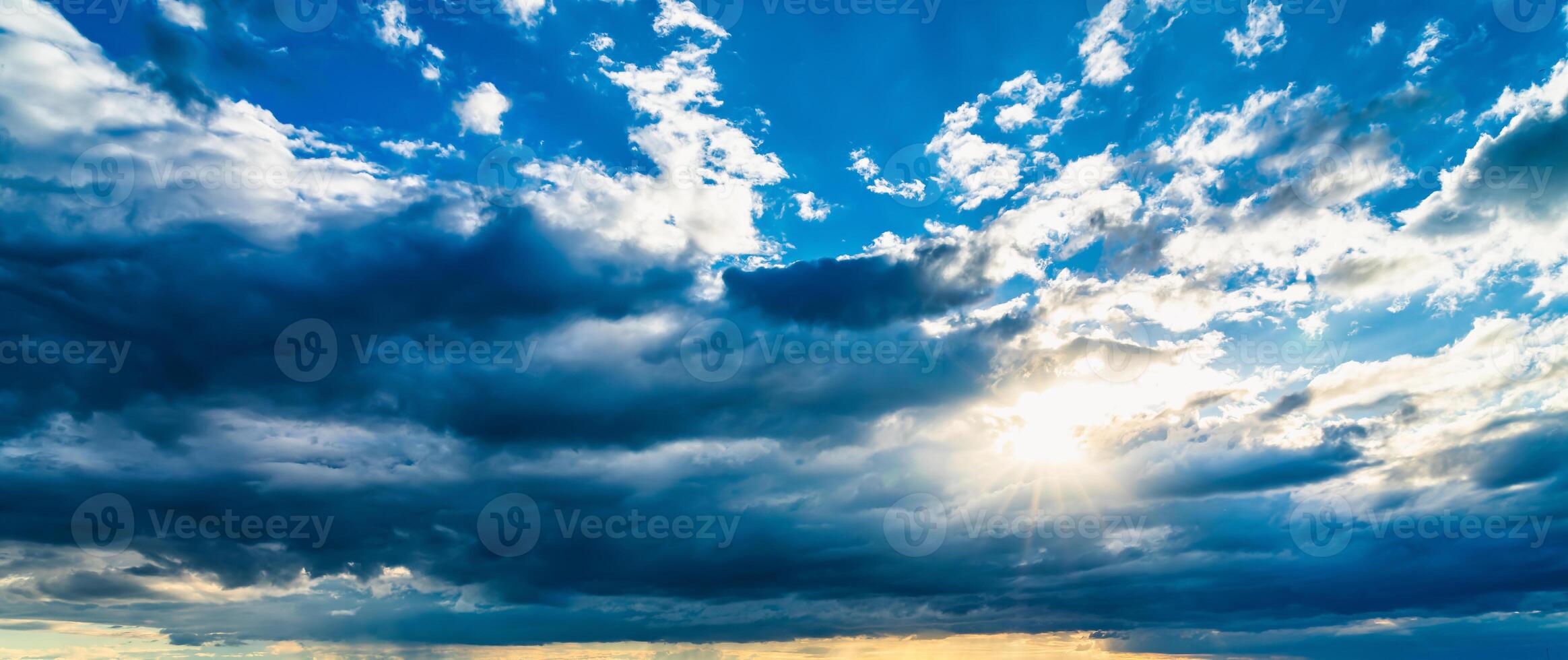 The sun breaking through storm clouds in a flowering rapeseed field. photo