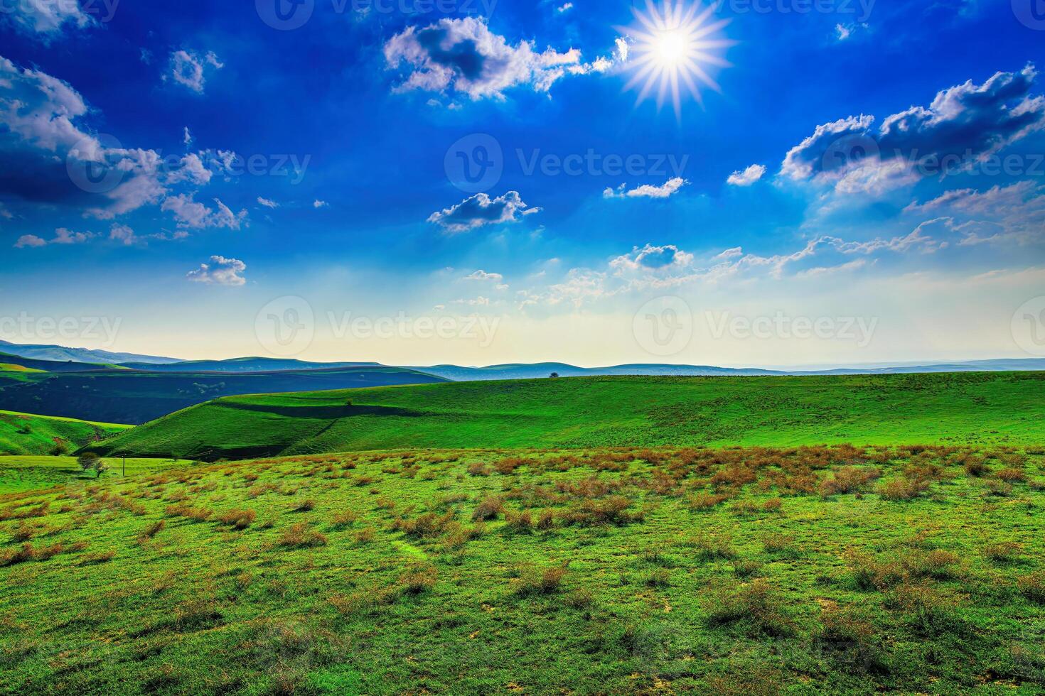 Hills and mountains covered with young green grass and illuminated by the sun on a sunny day. photo