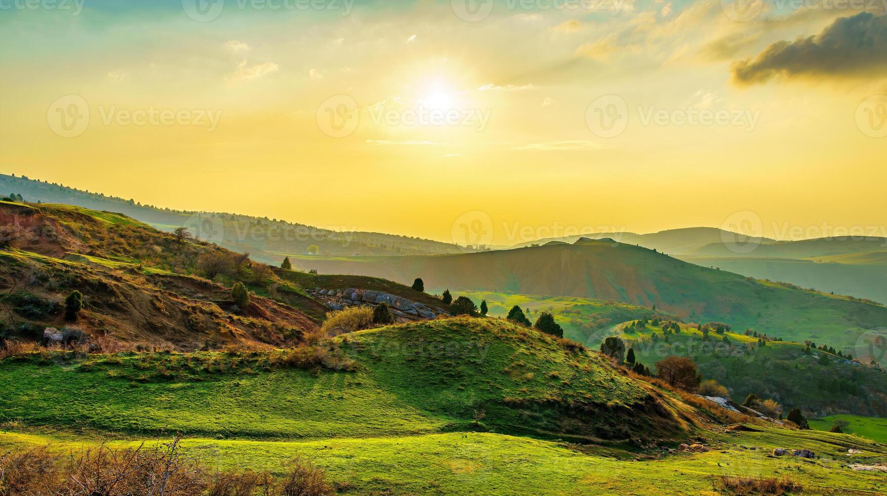 Foggy sunset or dawn in the mountains covered with grass and cloudy dramatic sky. photo