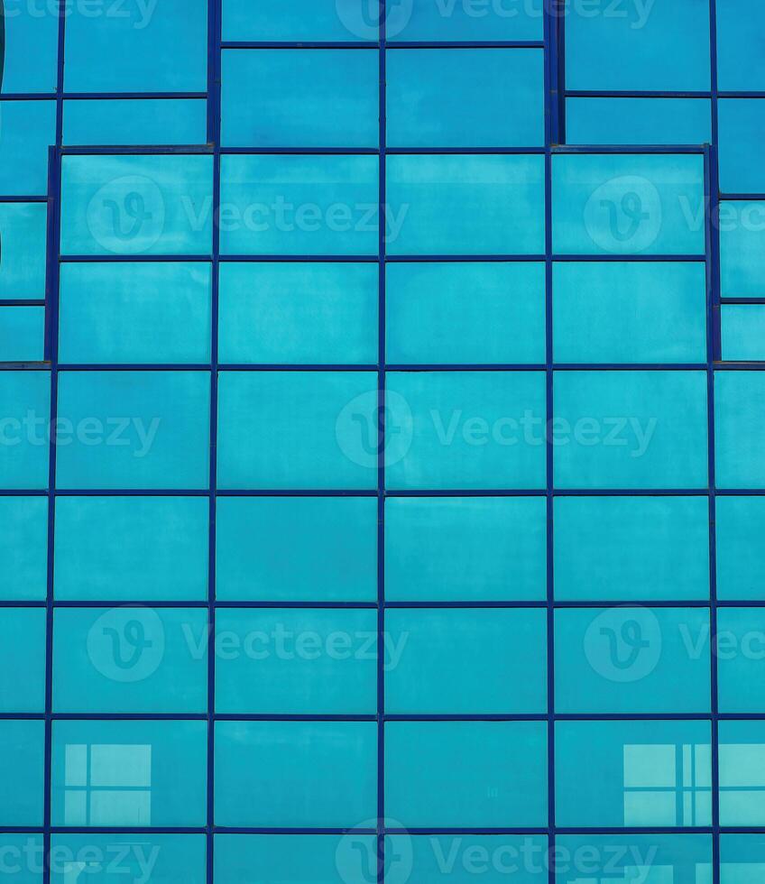 Fragment of a modern office building. Abstract geometric background. Part of the facade of a skyscraper with glass windows. photo