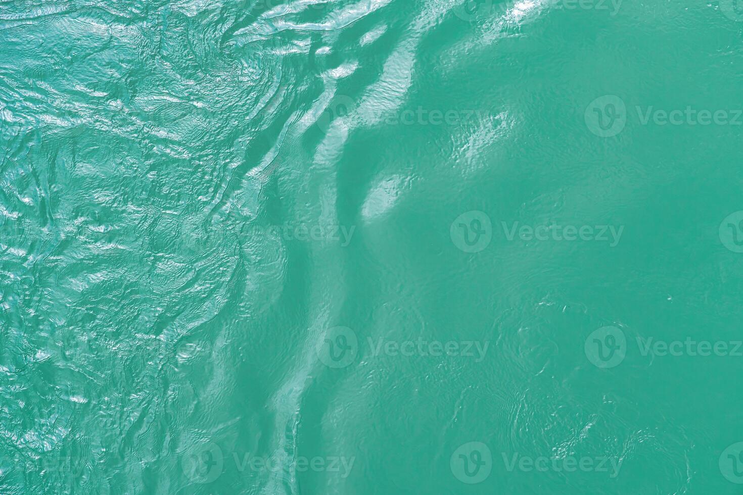 The texture of the waves of turquoise color of fast-flowing water in the river. photo